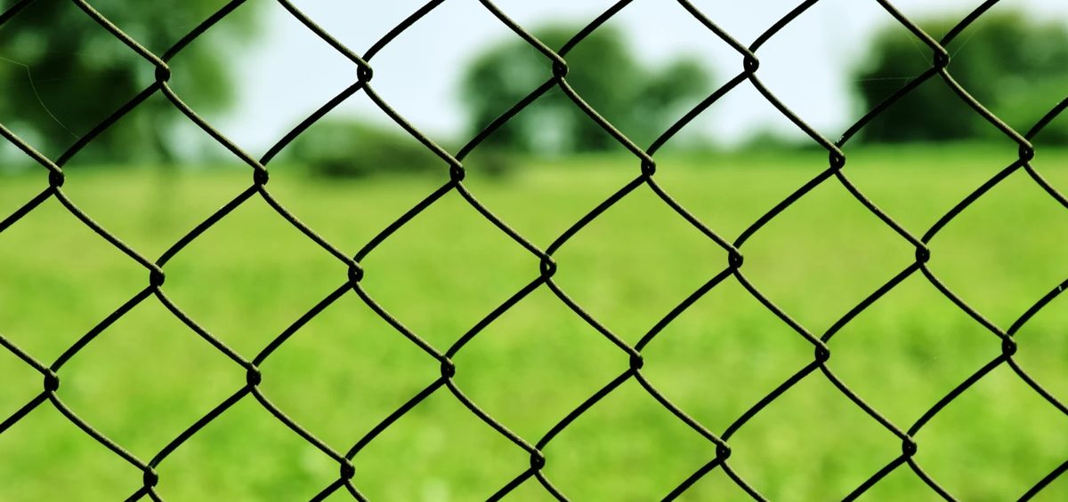 Chain link fence in a green field